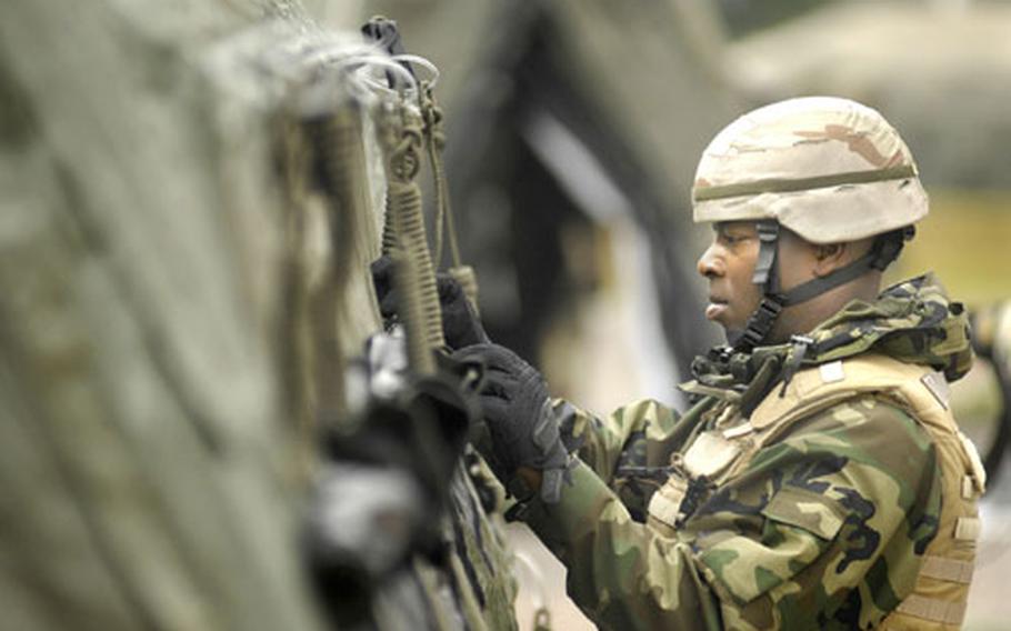 Air Force Tech. Sgt. Charles Higgins, an Air Transportation craftsman from the 86th Contingency Response Group, buttons up window flaps on a DRASH quick erect shelter during a training exercise at Ramstein Air Base.