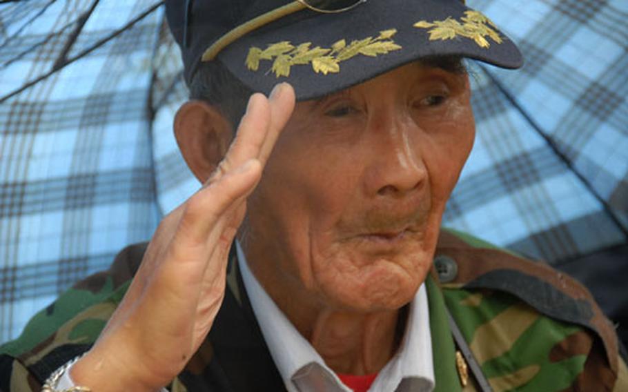 Cho Pyong-ung, 77, salutes as the Korean national anthem is played during the memorial service.