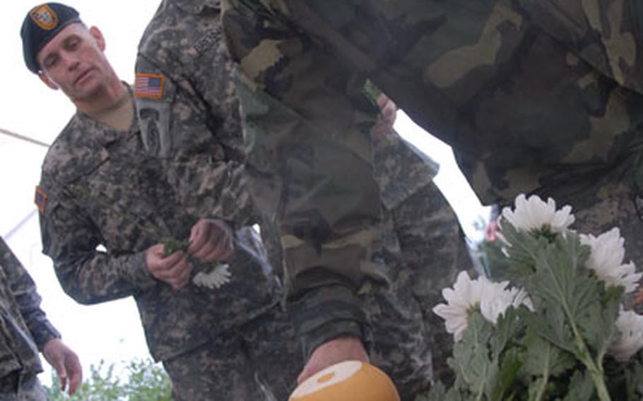 Members of the U.S. Special Operations Command Korea lay flowers on a table honoring Korean guerillas who fought against the North Koreans during the Korea War.