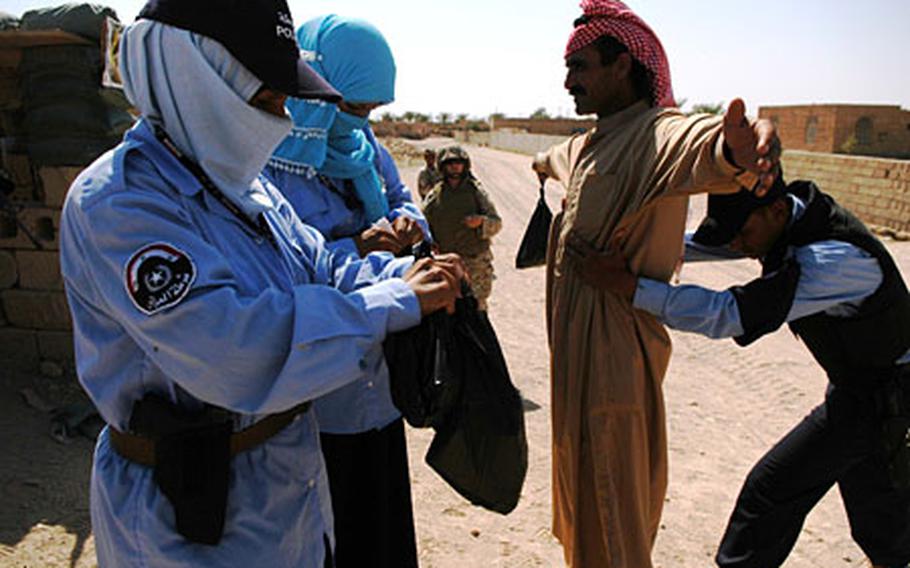 Female Iraqi Police officers help search those crossing through a checkpoint outside Ramadi. The need for women in a security role has been underscored by recent attacks by women and the cultural taboo that restricts males from searching females.