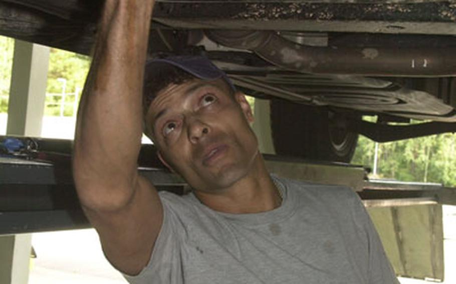 Aaron Cooper, an employee at the Auto Skills Center at Pulaski Barracks in Kaiserslautern, Germany, changes the oil in a vehicle on Monday. Air Force and Army auto skills centers in the Kaiserslautern area have seen the number of customers skyrocket with the closure of the Army and Air Force Exchange Service&#39;s Car Care Center garage last July. Kaiserslautern no longer has an AAFES garage to service the more than 50,000 Americans who live in the area.