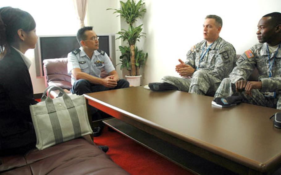 Capt. Will Hunter, second from the right, talks to Lt. Col. Masaru Ohta, the head of the Japanese 21st Air Defense Missile Squadron at Shariki, Japan. The American&#39;s missile radar unit abuts the Japanese air base, which houses four Patriot missiles.