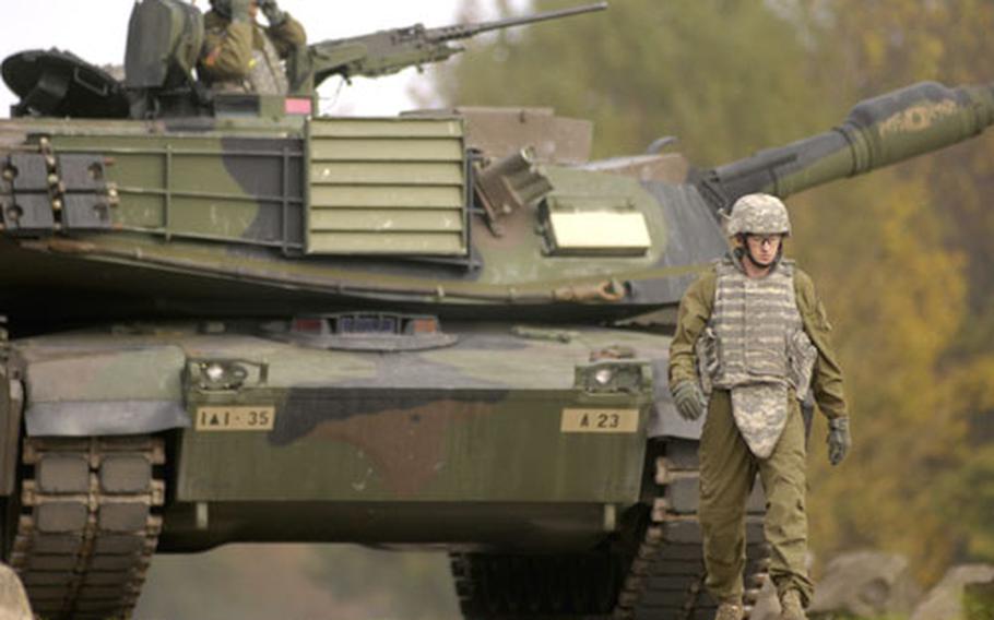 Pfc. Bradley Southard, a loader from 1st Battalion, 35th Armor Regiment “Iron Knights,” guides an M1A1 Abrams tank back from a live fire exercise Wednesday near Baumholder, Germany.