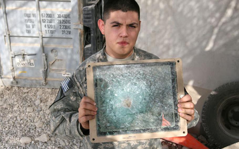 Spc. Gabriel Hernandez, 22, of San Antonio displays a bulletproof face shield that took a direct hit recently from a 7.62mm round fired by insurgents. The shield saved the gunner from being hit in the face.