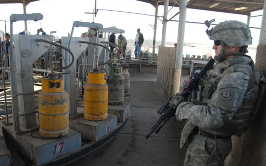 A 2nd Squadron, 2nd Cavalry (Stryker) Regiment soldier checks out the tank filling operation at Sarmoud Propane Station in Baghdad.