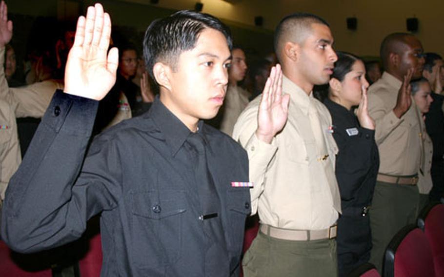 Seaman Miko Reves Batoon, 20, from the Philippines, with 3rd Marine Logistics Group, and Cpl. Jorge Bebelagua Del Pino, 20, from Cuba, with Marine Wing Headquarters Squadron 1, swear an oath of allegiance to the United States.