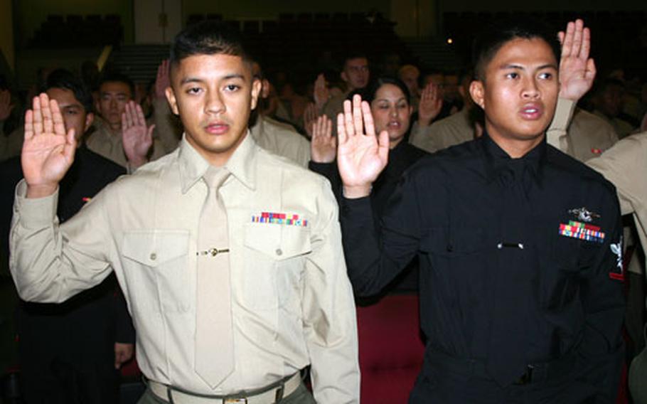 Cpl. Enrique Andrade Caleron, 21, from Ecuador, with Marine Wing Headquarters Squadron 1, and Petty Officer 3rd Clalss John Erwin Antonio, 24, from the Philippines, with 3rd Dental Battalion, swear an oath of allegiance to the United States during a naturalization ceremony. In all, 78 servicemembers became citizens in the ceremony.