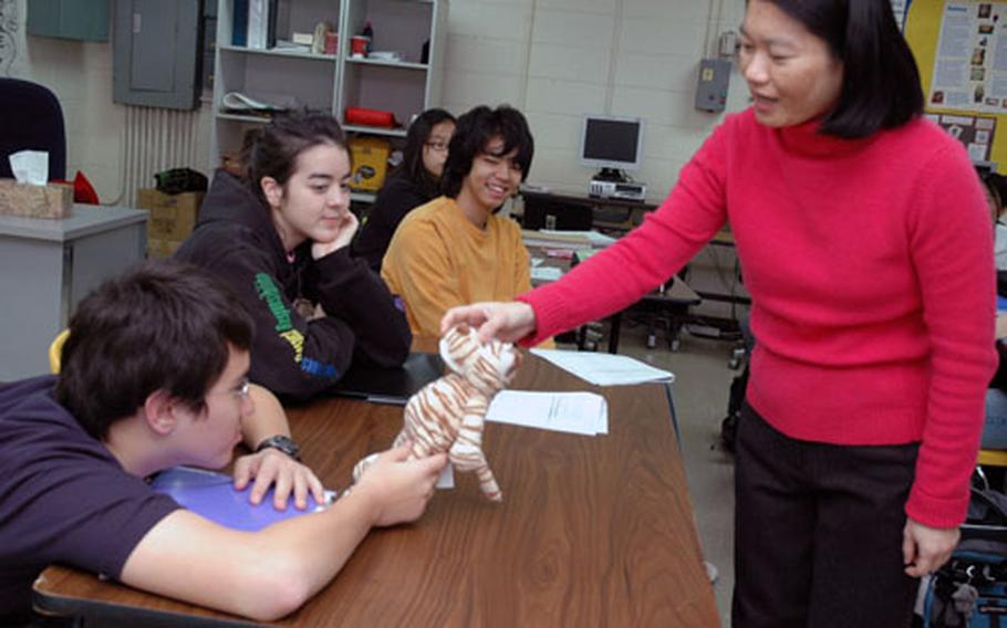 Chyong-yng Chang is in her second year teaching Mandarin to middle and high school students on Yongsan Garrison in Seoul. This first-year class has mostly middle school students, and she uses fast-paced games to keep them working. Here, she gives a student a tiger. The student must answer a question in Chinese, then toss the stuffed animal to a peer and continue the conversation.