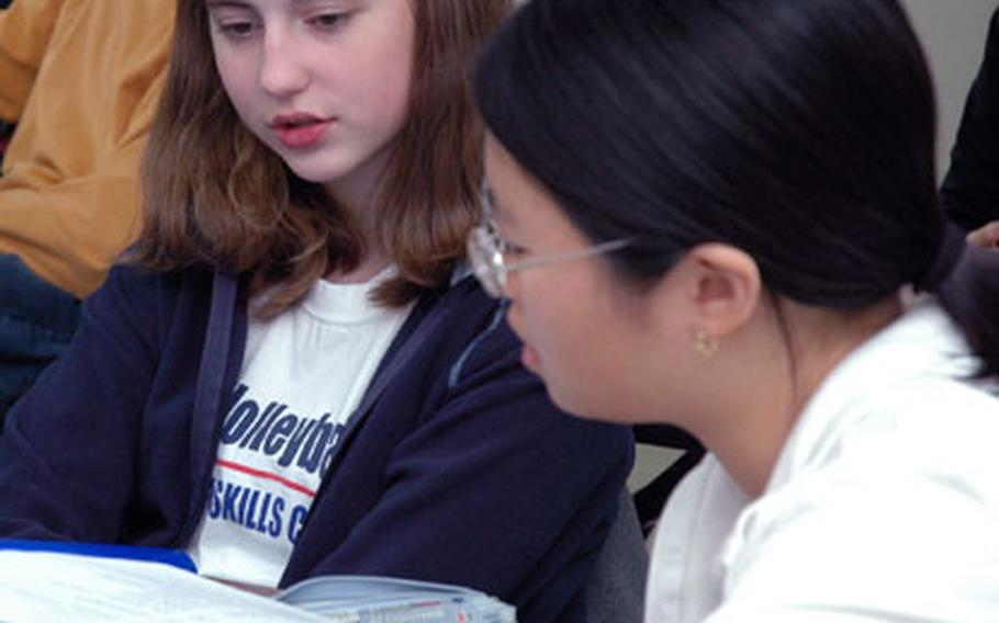 Jenna Weida, left, and Anna Kim practice conversation in Mandarin earlier this month in their Chinese language class at Seoul American High School. Jenna and Anna are eighth-graders, but they and many other middile school students go to the high school for the class. The Chinese program is in its second year at on-base schools in the Pacific, and so far it&#39;s showing a steady following.