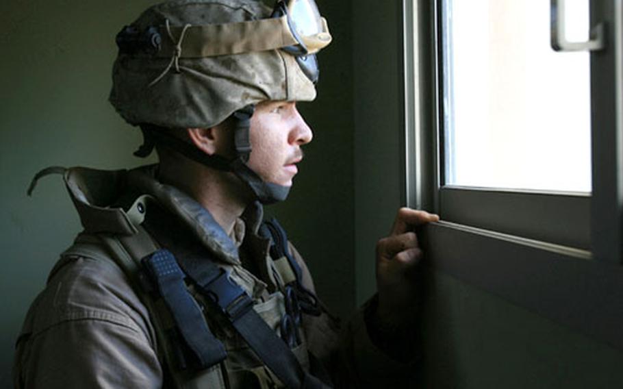 In this undated file photo, an unidentified Marine with Alpha Company, 3rd Reconnaissance Battalion, keeps a lookout from a building during the battalion's deployment to the Fallujah area of Iraq from September 2006 to April 2007.