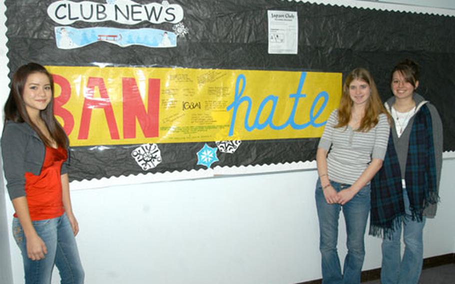 Emely Vallee, left, Samantha Cannon, center, and Stephanie Wehrung stand in front of a Gay-Straight Alliance banner in the hallway of Robert D. Edgren High School at Misawa Air Base, Japan. The new club at Edgren was formed to promote tolerance and awareness of others&#39; differences.