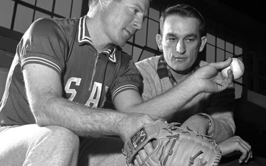 New York Yankees pitcher Whitey Ford gives pointers to Johnny Ross of the Darmstadt Comets during the USAFE clinic at Wiesbaden. Ross was the winningest lefthander in the Germany Conference over the previous three years; at one point in 1965, he won five games within eight days.