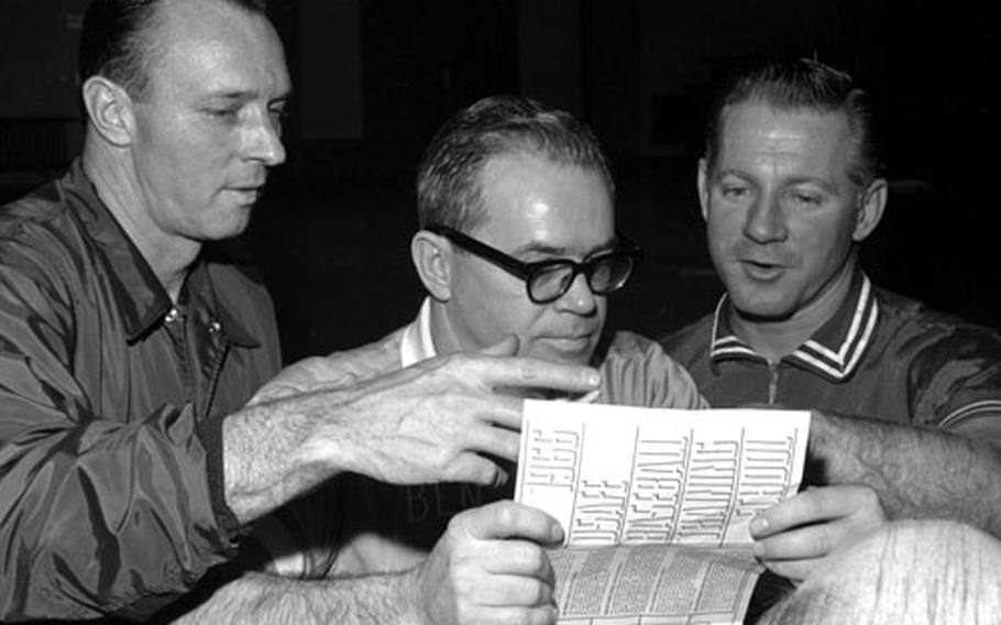 Left to right, Yankees coach Jim Hegan, Wiesbaden Air Base gym director Ben Royster and Whitey Ford look over a schedule for the clinic.