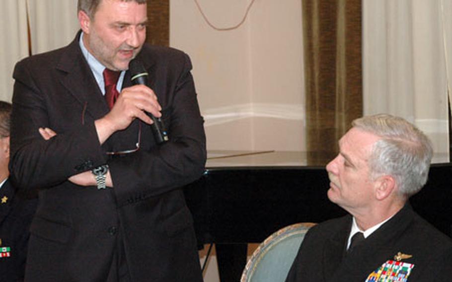 U.S. Rear Adm. Michael Groothousen, seated, listens as La Maddalena mayor Angelo Comiti speaks at the ceremony.