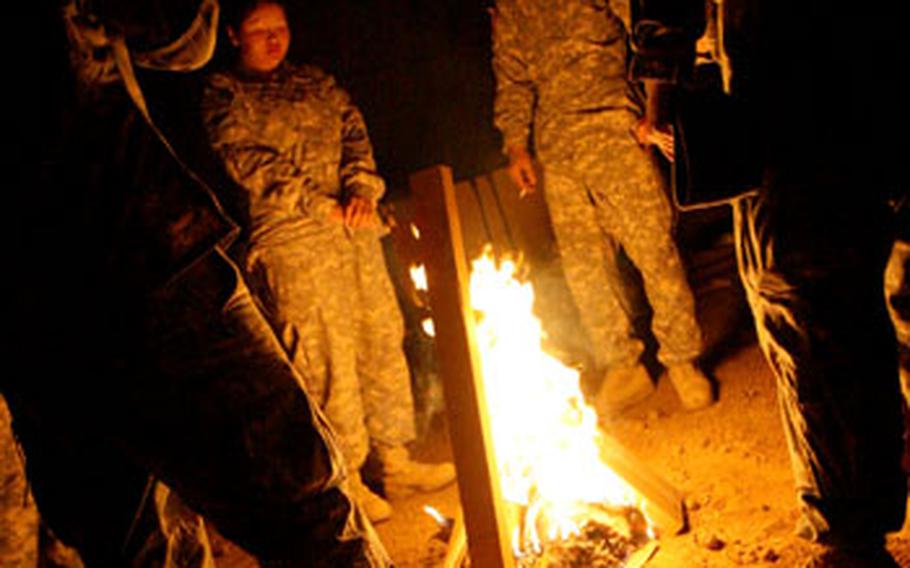 Soldiers from the 77th Engineering Company from Fort Leonard Wood, Mo., ward off the chilly night air around the fire, after a long day of building a new combat outpost in Mosul.