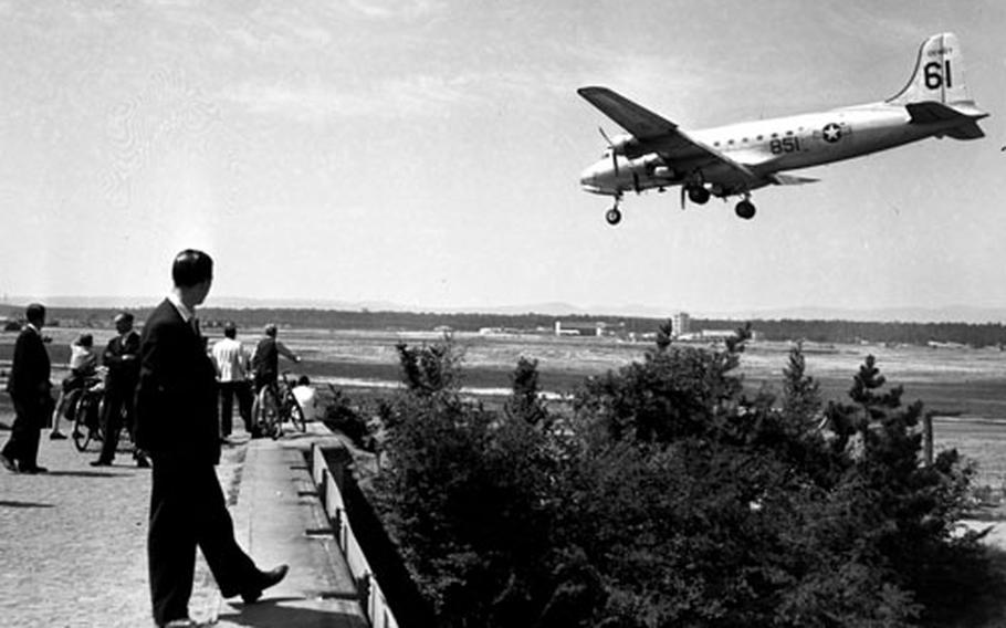 Watching Berlin Airlift flights arrive at a West German airfield for reloading provides local residents with a close-up look at history in the making in June, 1949.