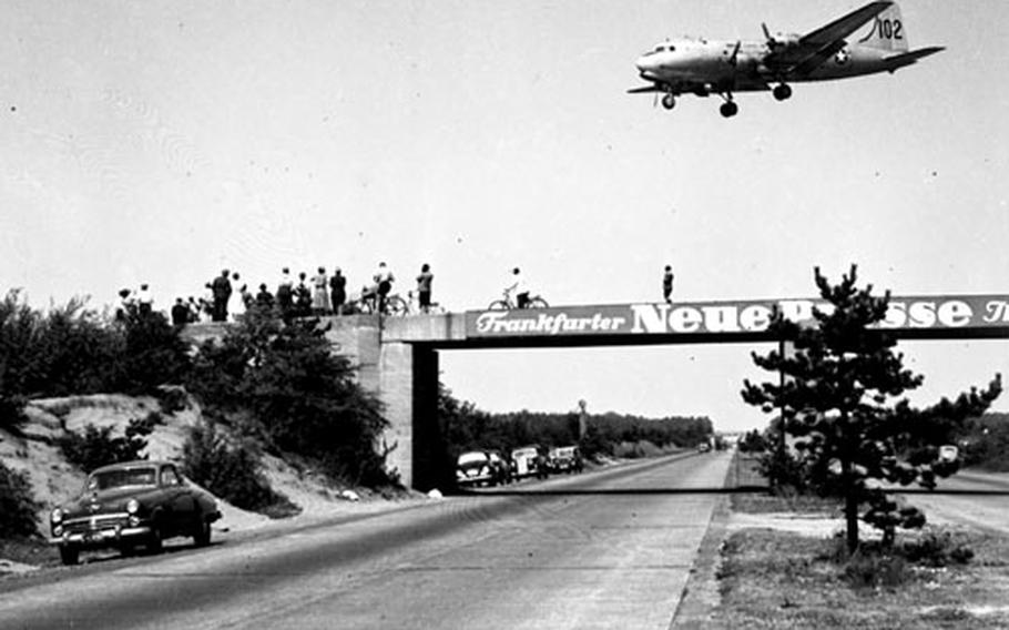 Watching Berlin Airlift flights arrive at a West German airfield for reloading provides local residents with a close-up look at history in the making in June, 1949.