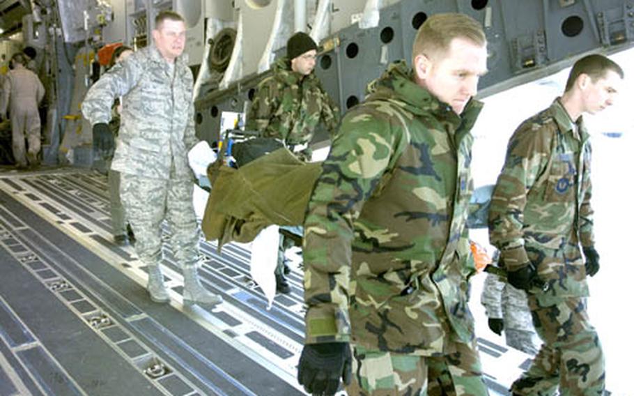 Capt. Ronald Eller, front left, Airman 1st Class Micheal Zangri, front right, Lt. Col. David Levitt, back left, and Master Sgt. Joseph Schleper, all airmen from the 435th Contingency Aeromedical Staging Facility, transport a wounded servicemember from a C-17 to a bus bound for Landstuhl Regional Medical Center on Friday on the Ramstein Air Base flight line. Maj. Langevin is the CASF commander.