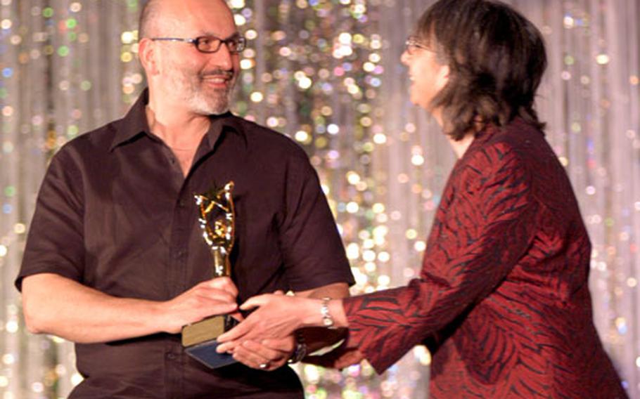 Dan LaMorte, SHAPE&#39;s entertainment director, accepts one of the community theater&#39;s 11 awards Saturday. SHAPE was outdone only by Ankara, Turkey&#39;s Stage on the Run theater, which grabbed 13.