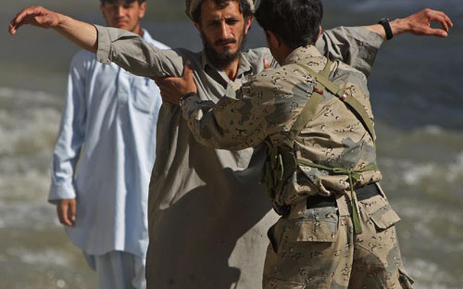 An Afghan border policeman searches a man before allowing him to pass a checkpoint in Gowardesh Valley in east Afghanistan’s Nuristan province.