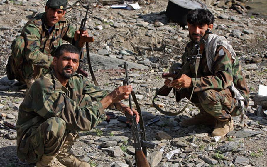 Afghan National Army troops pause while cleaning their weapons by the Kunar River in Gowardesh Valley in east Afghanistan’s Nuristan province.