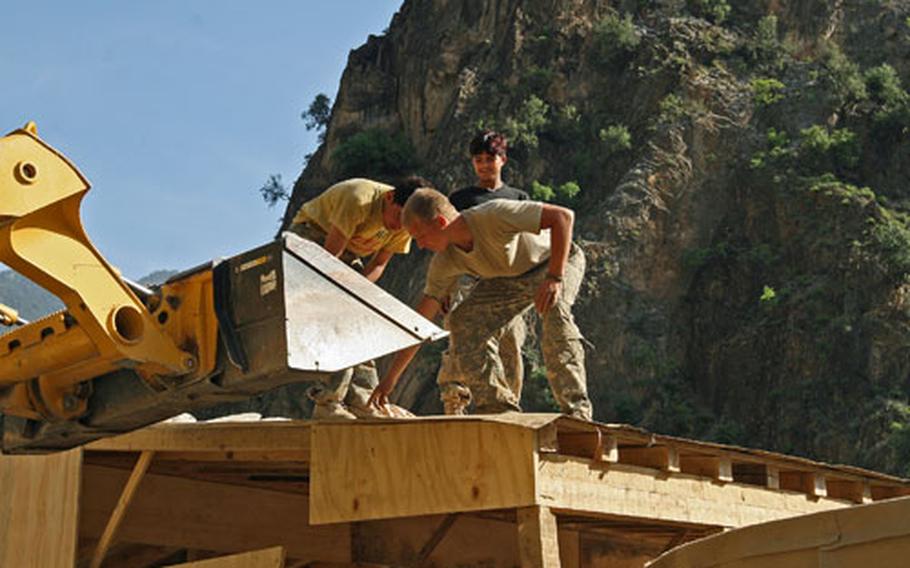 Spc. Jason Marlowe, 23, of Milwaukee, directs work on the roof of an Afghan border police checkpoint in the Gowardesh Valley in east Afghanistan.