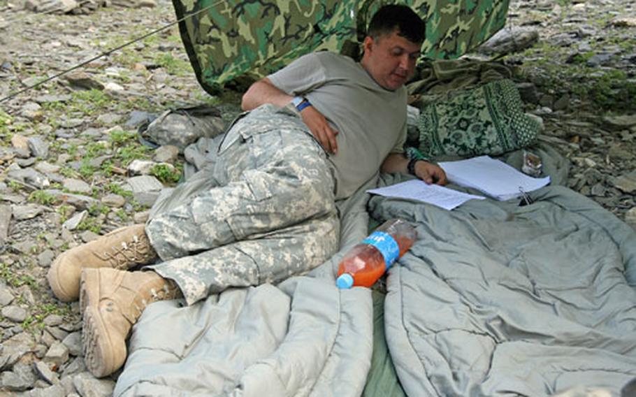 While other soldiers play cards to pass the long afternoons in the Gowardesh Valley, in Afghanistan’s Nuristan province, Spc. Taquiudson De Almeida, 36, of Boston, studies for a test to make sergeant. A native of Brazil, De Almeida spent a year in the Brazilian army special forces before joining the U.S. Army.