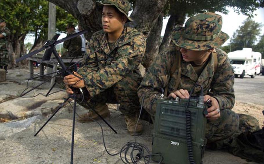 Lance Cpl. Alan Bundoc, left, and Pfc. Darrel Slaven, both with Combat Logistics Battalion 31, 31st Marine Expeditionary Unit, set up a communications link shortly after going ashore at Sattahip, Thailand, on Thursday from the forward-deployed amphibious assault ship USS Essex. The 3st MEU and the Essex are among the military units participating in Cobra Gold 2008, which is scheduled to end May 21.