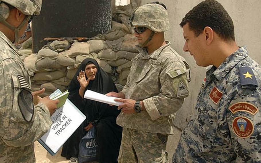 Lt. Hidar Nahdi Asah [right], head of the Iraqi National Police at the Joint Security Station, an Iraqi interpreter and Sgt. Arturo De La Garza [left], a soldier from Task Force 1-35, talk with an Iraqi woman in search of her son’s cell phone Wednesday in Jisr Diyala, Iraq. The JSS, staffed by U.S. Army and Iraqi National Police, is similar to a 911 center intended to help assist Iraqis with security and compensation claims.