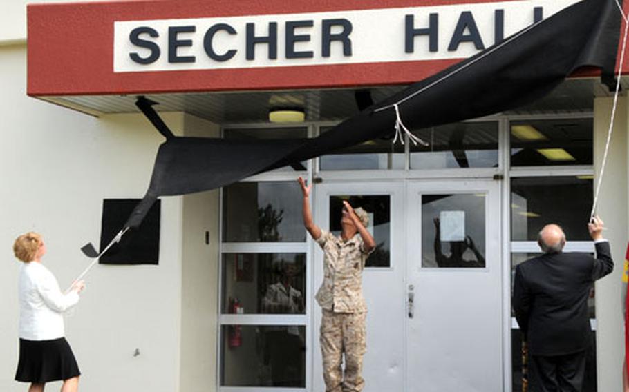 Elke Morris and Dr. H. Pierre Secher unveil the new name for a 12th Marine Regiment training facility on Camp Hansen Friday that was named for their son, Capt. Robert M. Secher.