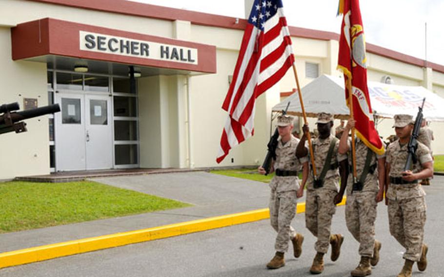 A Marine color guard marches past Secher Hall on Friday during the ceremony.