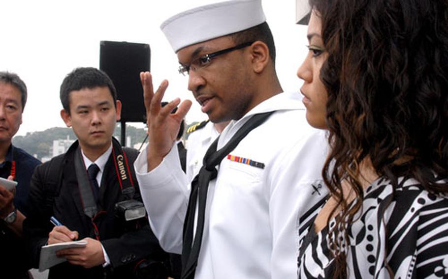 USS Kitty Hawk Seaman Phillip Simmons, in uniform, explained to reporters Monday how he saved the life of a Japanese man at a local train station. Simmons is engaged to Marie Onaga, right.