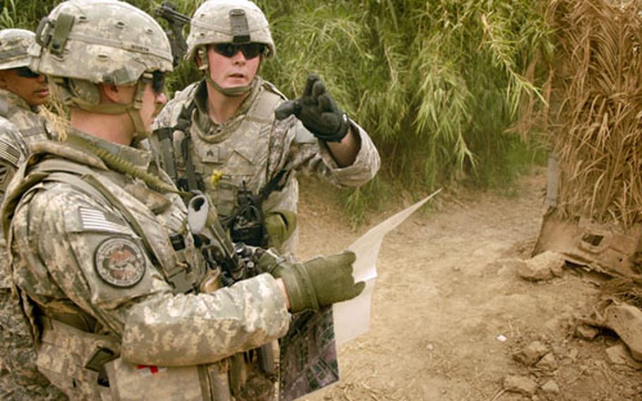 Sgt. Timothy Butler and 1st Lt. Jake Worth, both from Ghost Troop, 2nd Brigade’s reconnaissance team, study the terrain during a patrol in the town of Nasif just outside Combat Outpost Cahill Sunday.