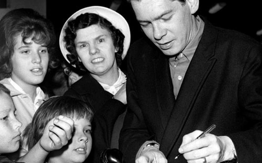 Johnnie Ray signs autographs at Wiesbaden, Germany, in 1961.