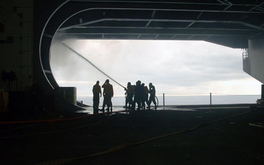 Sailors work to put out a fire from Hangar Bay 3. The cause of the fire and the extent of the damage are currently under investigation as the ship continues on course for San Diego.
