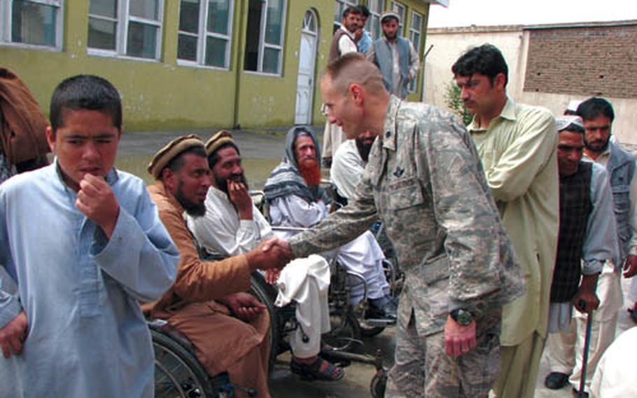 Lt. Col. Paul Donovan, Nangarhar Provincial Reconstruction Team commander, shakes hands with Afghan men during a ribbon-cutting ceremony for an $80,000 facility that will house more than 200 disabled men who had been sleeping in tattered tents.
