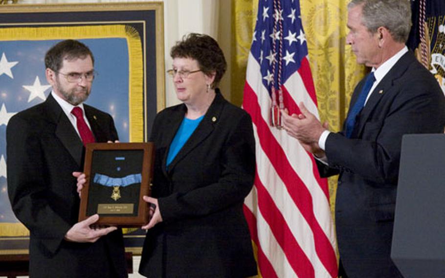 President Bush applauds as Tom and Romayne McGinnis display their late son&#39;s Medal of Honor Monday at the White House.