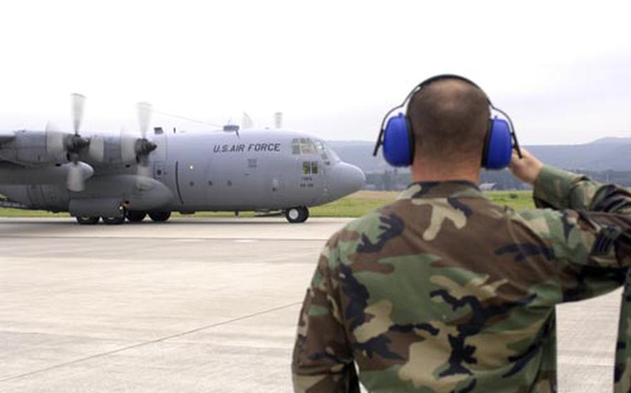 An airman with the 86th Airlift Wing salutes on Wednesday at Ramstein Air Base, Germany, as C-130E cargo aircraft "63-7865" taxis down the runway for its final flight before retirement. This summer, the wing will retire five of its aging C-130E aircraft.