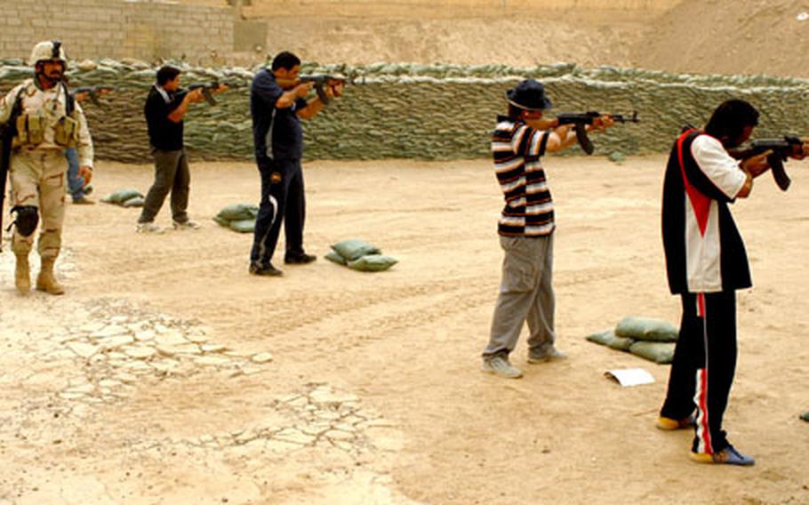 Sgt. Mohammad, with the 3rd Battalion, 42nd Brigade, 11th Iraqi Army Division, instructs "Neighborhood Guard" recruits from the Jamilla neighborhood of the Sadr City district of Baghdad on Tuesday. They were learning to fire AK-47 rifles at a range on Forward Operating Base War Eagle in northern Baghdad.