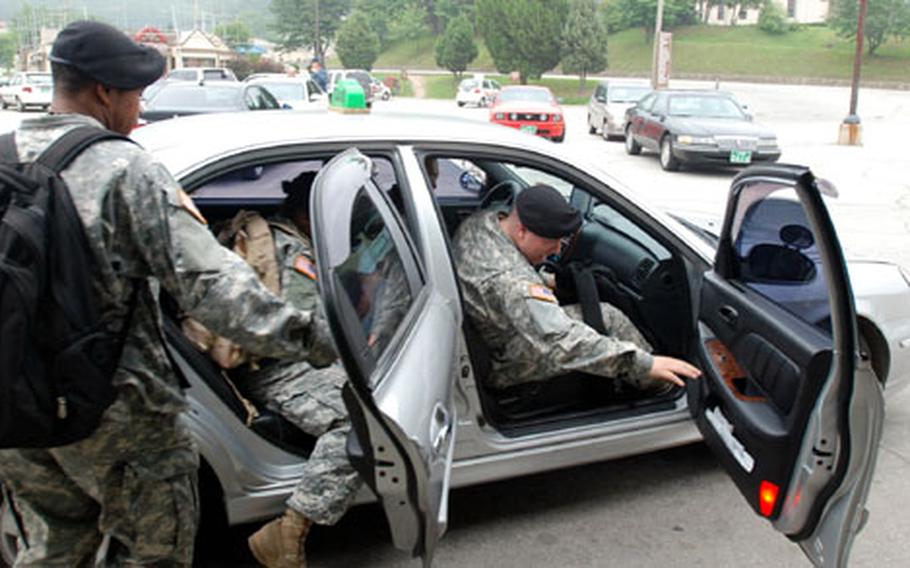From left, Pvt. William Graham, Pfc. Katherine Esqivel and Pfc. Scott Smart get in a taxi on Camp Casey after waiting about 30 minutes Friday. The post will receive an additional 50 taxis this week.