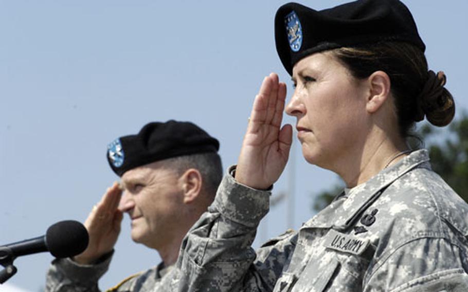 Army Col. Robin Akin, commander of the 29th Support Group, right, and Major Gen. Yves Fontaine, commander of the 21st Theater Sustainment Command, salute during the playing of the National Anthem during the 29th Support Group&#39;s deactivation ceremony.