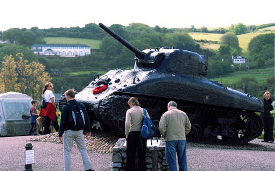 Visitors examine the memorial to the participants of Exercise Tiger at Slapton Sands. This Sherman tank was recovered from the waters off Britain in 1984, 40 years after the exercise.