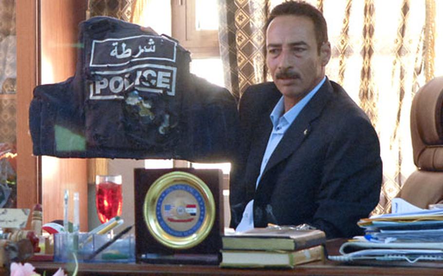 Tal Afar Mayor Najim Abdullah Al Jabouri holds up a bullet-riddled ballistic vest that he wore when he first came to the city three years ago. Al Jabouri is proud of staying with Tal Afar through its roughest fighting and looks down on those who he thinks can’t control the violence in neighboring Mosul.