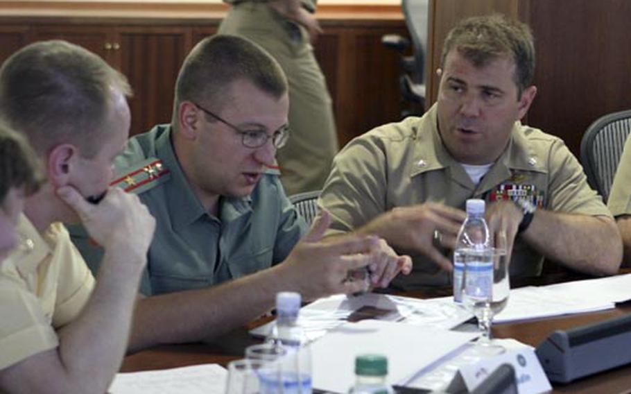 Cmdr. Greg Molinari, far right, discusses future plans with a member of the Russian Federation Navy at two-day staff talks between the navies held at Naples, Italy. The conference revolved around the planning of future military-to-military engagements including exercises, key leadership events and operational missions.