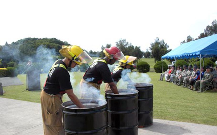 Kadena Air Base firefighters place flares inside bins containing worn flags during a flag retirement ceremony Friday. About 40 flags were retired, including Japanese, United Nations and Air Force.
