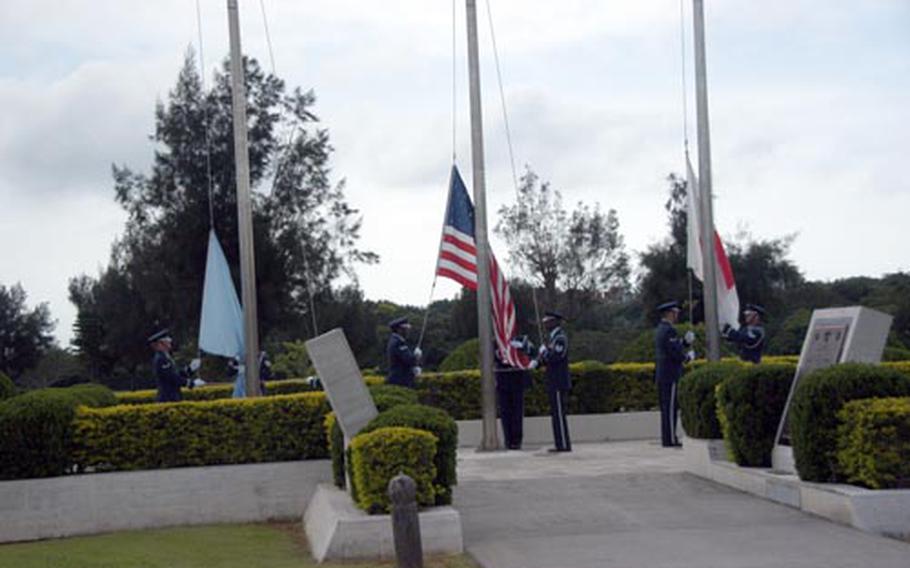 Kadena Air Base color guard retreat the commissioned flags displayed outside 18th Wing Headquarters. The three flags were placed in a bin to be properly retired and burned.