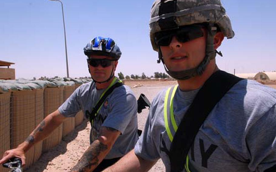 Sgt. Terryll Williams, left, and his son Spc. Mathew Williams sit on their bikes Friday at Forward Operating Base Q-West. The two saw each other only sporadically while Mathew was growing up, but they get to see each other every day now that they’re in the same squad. The elder Williams volunteered to come to Iraq as part of a promise he made to his son. “It’s the right thing to do,” he said. “It’s a rare opportunity.”