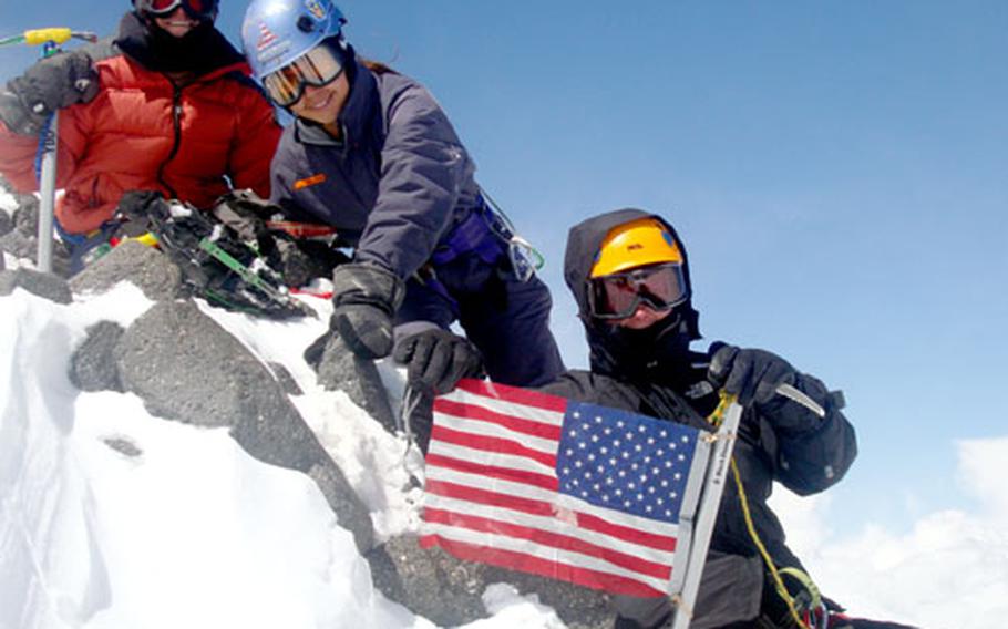 Jodi Pallet, left, Sierra Young-Dong, and Yvonne Dong, right, display an American Flag at the 18,506-foot peak of Mount Elbrus, in the Republic of Georgia, after more than eight hours of climbing on May 22.