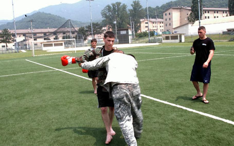 Spc. Joshua Reid, standing, of the 2nd Infantry Division&#39;s 2nd Battalion, 9th Infantry, spars with Pvt. Johnny Herrera at Soldier Field on Camp Casey on Friday. The field showed elevated levels of lead but remained within safety limits, military officials said Friday. A field at Camp Henry closed due to higher lead levels.