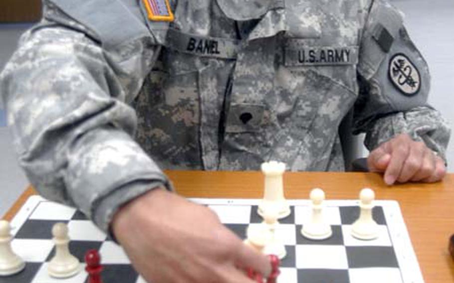 Spc. Jhonel Baniel, a respiratory specialist at Landstuhl Regional Medical Center, Germany, re-creates the final move that gave him the 2008 U.S. Armed Forces Interservice Chess Tournament championship. Baniel’s moved his queen to take his opponent’s remaining bishop, putting Air Force surgeon Dr. (Col.) Samuel Echaure in check. Echaure conceded the match after Baniel’s move. The U.S. Armed Forces Interservice Chess Tournament was a seven-round tournament held June 9-12 at Davis-Monthan Air Base in Arizona.